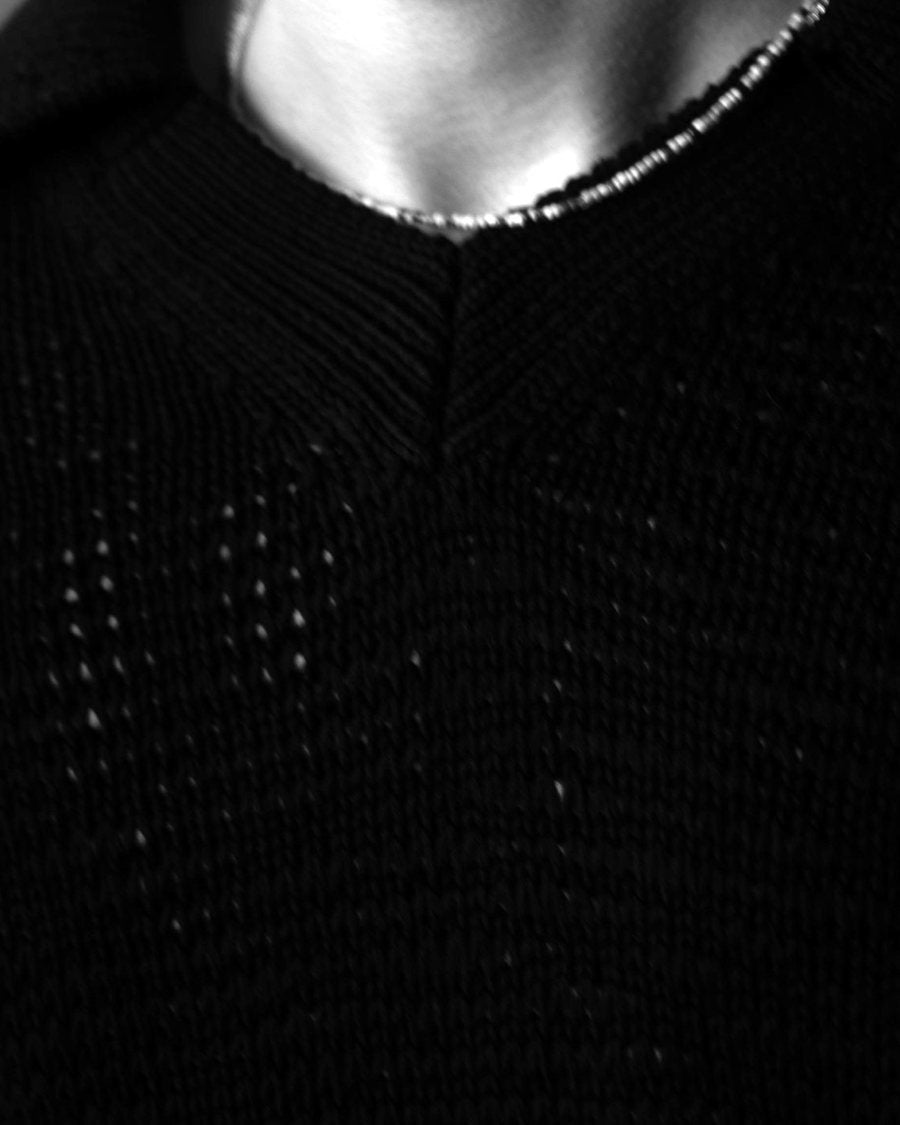 The black knit's V and the beaded chain